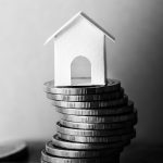 obrazek nawiązujący do ubezpieczenia majątkowego poprzez monety i dom