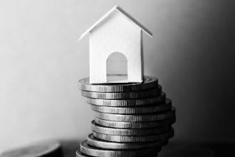 obrazek nawiązujący do ubezpieczenia majątkowego poprzez monety i dom