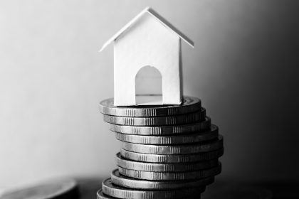 obrazek nawiązujący do ubezpieczenia majątkowego poprzez monety i dom