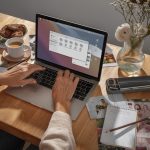 Osoba pracująca przy laptopie nad projektem i inspiracjami wizualnymi, planująca układ treści w procesie profesjonalnego tworzenia stron internetowych.