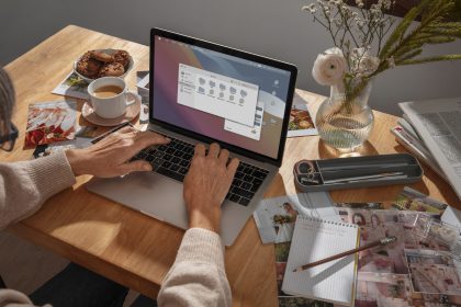 Osoba pracująca przy laptopie nad projektem i inspiracjami wizualnymi, planująca układ treści w procesie profesjonalnego tworzenia stron internetowych.