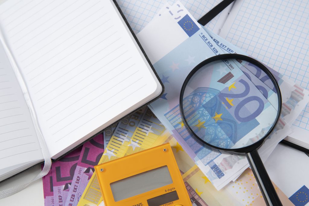 Lupa, kalkulator i notatnik służące do analizy inwestycji w fundusze akcyjne.