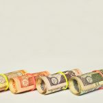 Zwinięte banknoty rupii indyjskich spięte kolorowymi gumkami symbolizujące oszczędności i zarządzanie pieniędzmi.